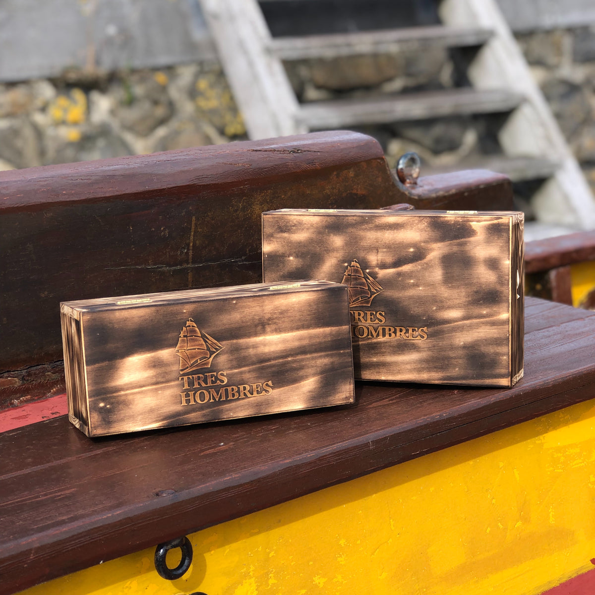 Two rectangular wooden boxes with the 'TRES HOMBRES' logo printed on the front. These are special boxes for the nex Tres Hombres Captain's Choice Rums "The King" and "The Queen".